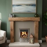 Wooden fireplace with a lit fire, surrounded by decorative items and a painting on the wall.